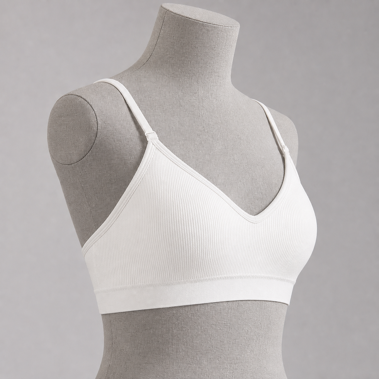 Top deportivo blanco con tirantes regulables, vista lateral.