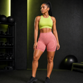 Modelo con pantalón corto deportivo rojo coral de cintura alta