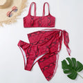 Bikini de tres piezas rojo con estampado de serpiente y pareo a juego.