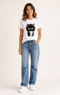 Mujer con camiseta blanca estampada de gato negro y taza