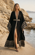 Mujer con vestido maxi bohemio negro y detalles geométricos en la playa