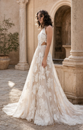 Novia con vestido A-line de tul ilusión y apliques florales en un patio de piedra